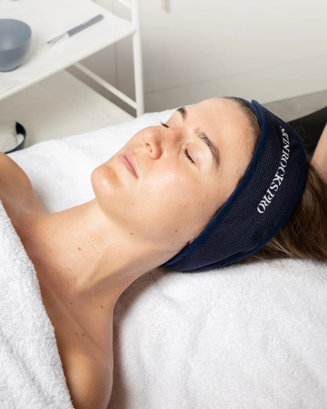 Client mid-Hydration Facial — Skin Rocks Pro headband, skin glowing.